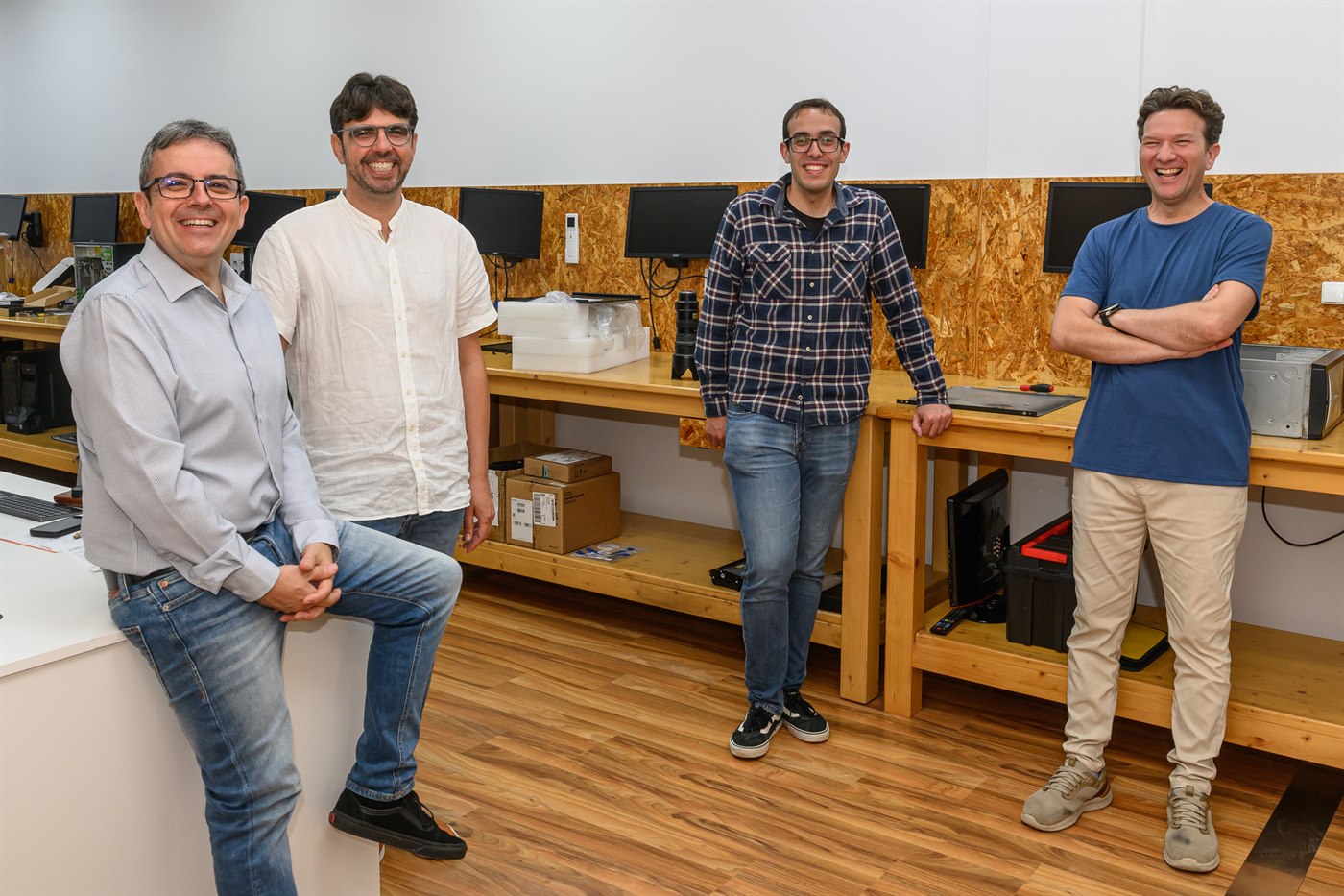 Cuatro personas del equipo de SAV en el taller, junto a los bancos de trabajo
